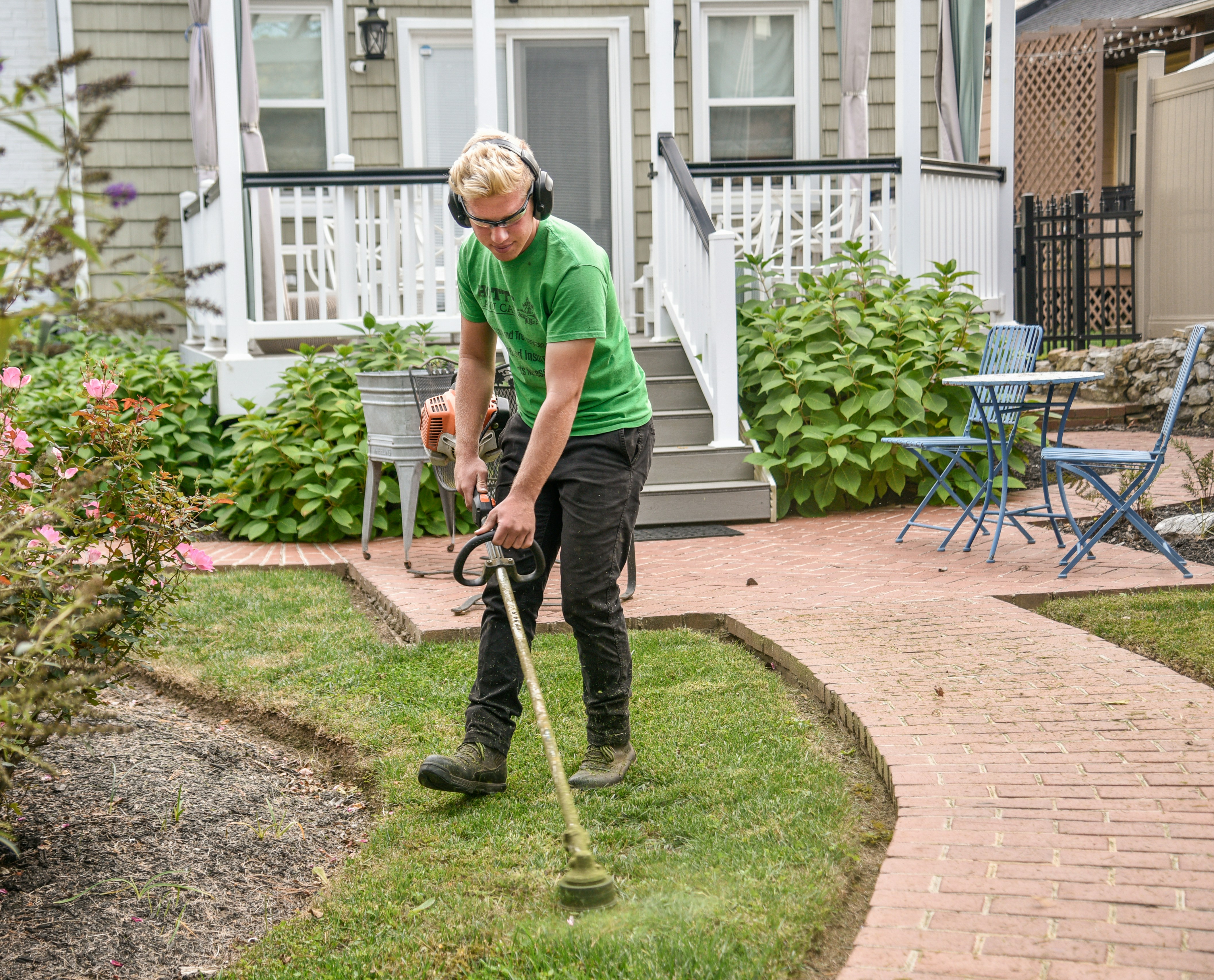 Before and after: overgrown backyard transformed into manicured lawn with fresh mulch beds